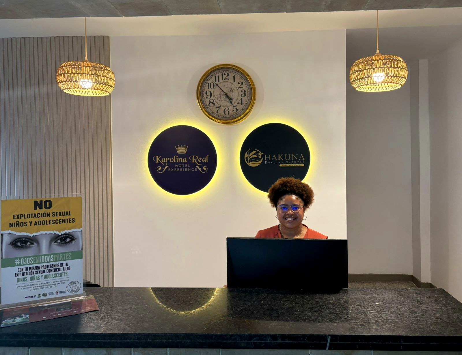 Recepción del hotel con una recepcionista detrás del mostrador